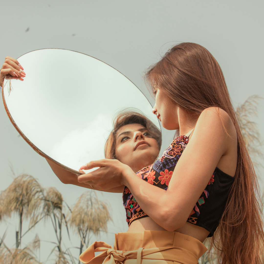 Arty photo of women looking at alternative self in mirror